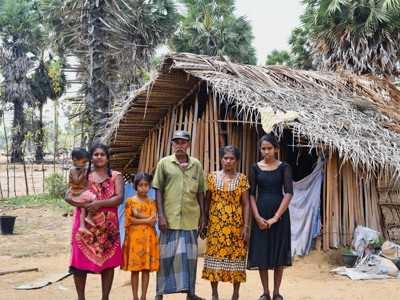 A family stands in front of their home.