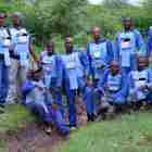 A group of deminers pose outside wearing PPE
