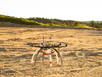 A drone used to identify mines and other explosive ordnance on the sandy soil of a minefield