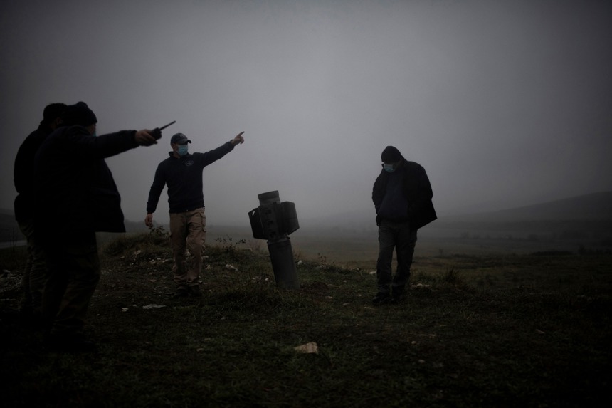 HALO Trust workers stand next to a grave in the fog in Nagorno Karabakh