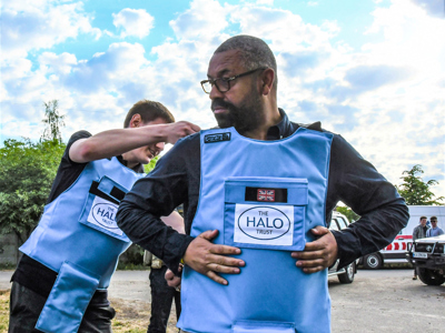 A HALO staff member helps James Clever put on his PPE