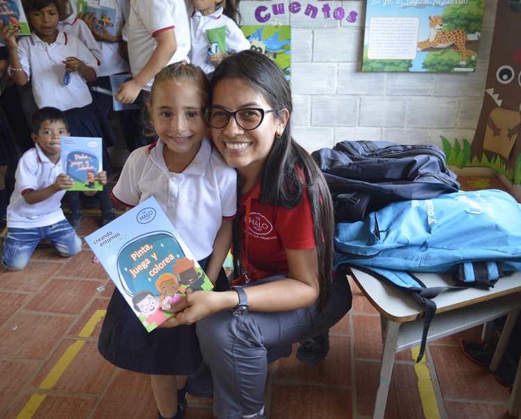 A HALO risk educator poses with a school child in a class after a explosive ordnance risk education session