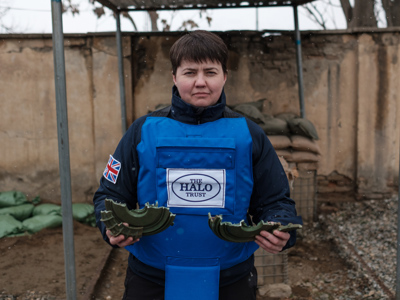 Ruth Davidson stands with a destroyed landmine cut into two pieces in her hands