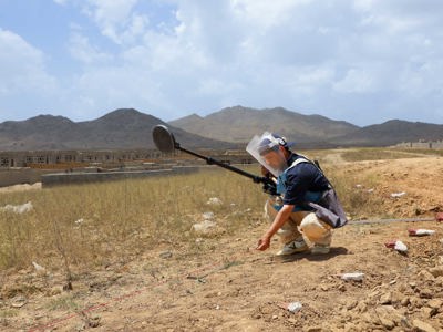 HALO Trust deminer places a marker on the ground following the positive signal from a metal detector in a minefield in Afghanistan