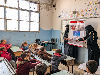 Children sit in a classroom for a risk education session led by HALO staff members
