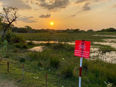 A flooded minefield in Sri Lanka with the sun setting in the background