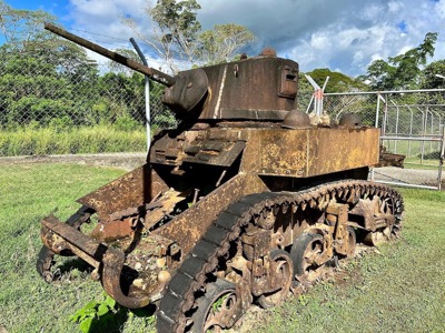 A rusted WW2 tank in a fenced off area in the Solomon Islands