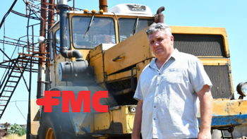 Serhii Kishkovskyi, a Ukrainian farmer stands in front of his farming vehicle in a field